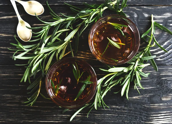 Cold rosemary tea with ice on wooden table — Stock Photo, Image
