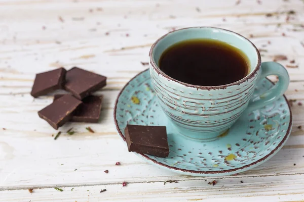 Tasse Kaffee, dunkle Schokolade auf Holztisch — Stockfoto