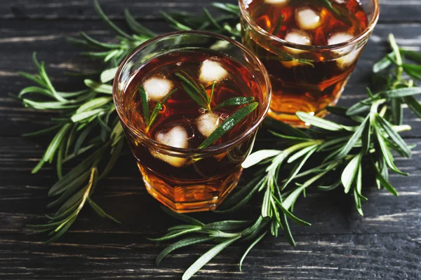 Cold rosemary tea with ice on wooden table — Stock Photo, Image