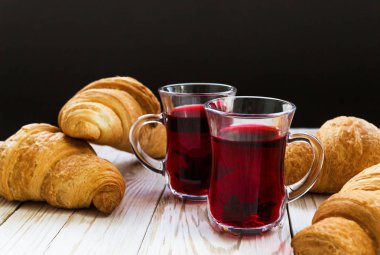 Taze kruvasanlar ve sıcak hibiscus çay bardak