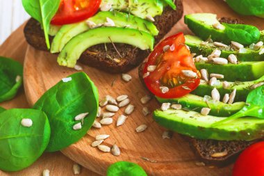 Dilimlenmiş avokado, domates, ıspanak ve baharat tost