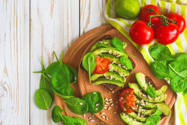 Dilimlenmiş avokado, domates, ıspanak ve baharat tost