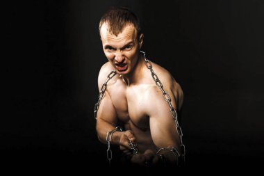 adam güçlü kaslı kollarıyla zincir çekerek