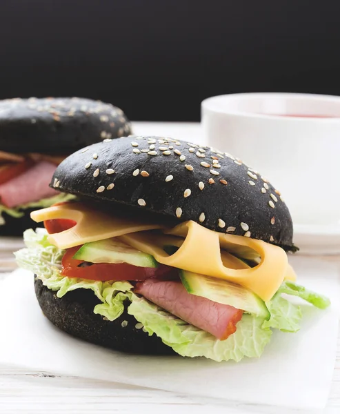 Hamburger nero, tazza di tè per la colazione . — Foto Stock