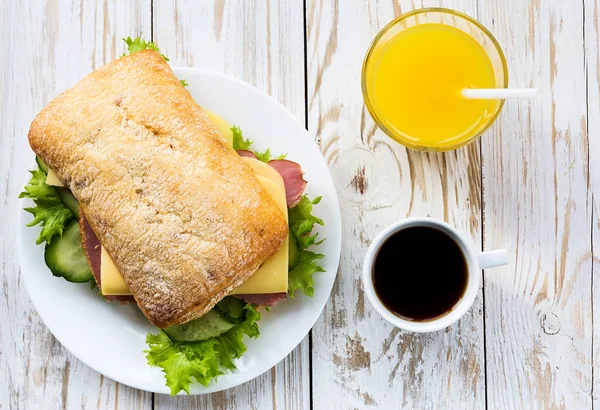 Chiabatta sandviç, kahve ve portakal suyu fincan — Stok fotoğraf