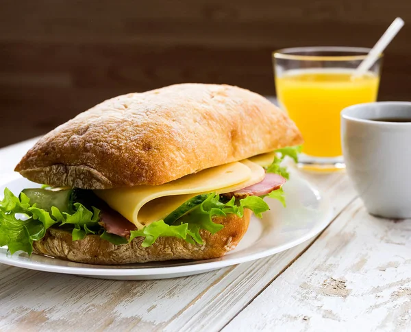 Chiabatta σάντουιτς, φλιτζάνι καφέ και πορτοκαλί χυμό — Φωτογραφία Αρχείου