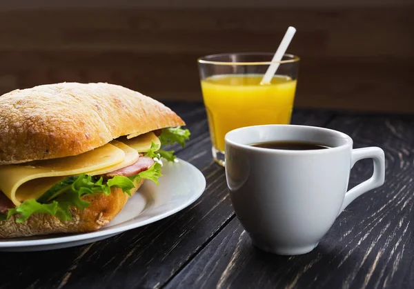 Chiabatta-Sandwich, Tasse Kaffee und Orangensaft — Stockfoto