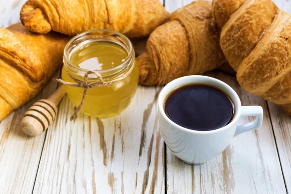 Свежие круассаны, мед и чашка эспрессо — стоковое фото