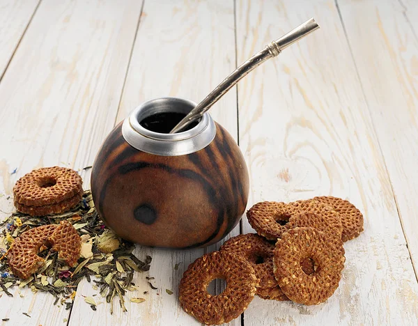 Yerba mate tea in a wooden calabash and cookies