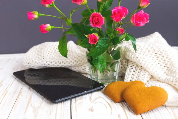 Warm knitted plaid, bouquet of roses and tablet