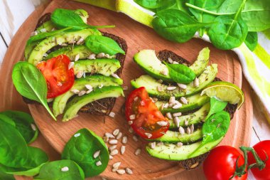 Dilimlenmiş avokado, domates, ıspanak ve baharat tost