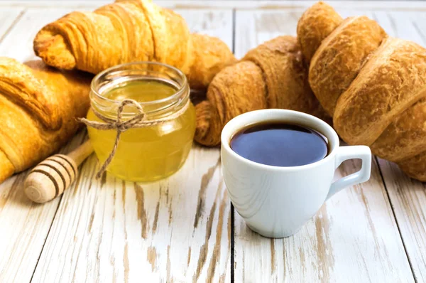Свежие круассаны, мед и чашка эспрессо — стоковое фото