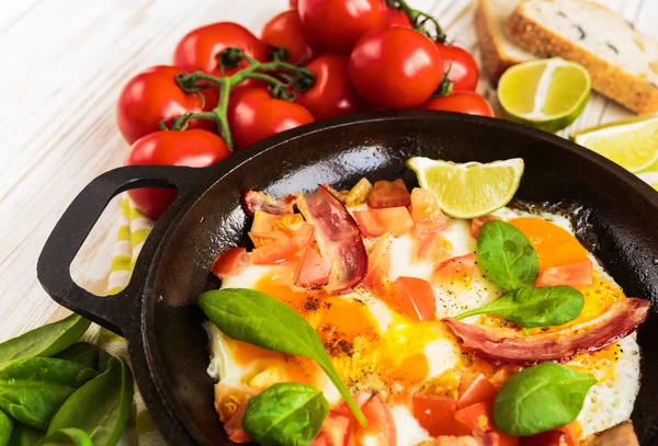 Pan smażone jajka, pomidory, boczek, szpinak, cytryna — Zdjęcie stockowe