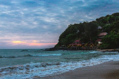 Egzotik plaj. Deniz ve bulutlu gün kayalarda.