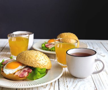 Burger sandviç, kahvaltıda çay ve portakal suyu fincan