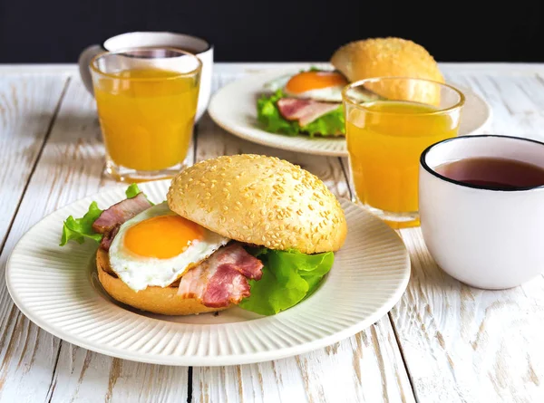 Burger sandwich, cup of tea and orange juice for breakfast