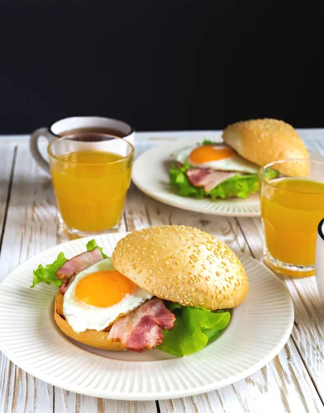 Burger sandwich, cup of tea and orange juice for breakfast