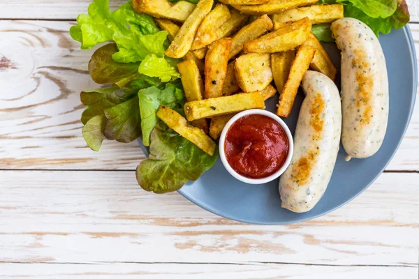 French fries, ketchup, grilled sausages and green salad.