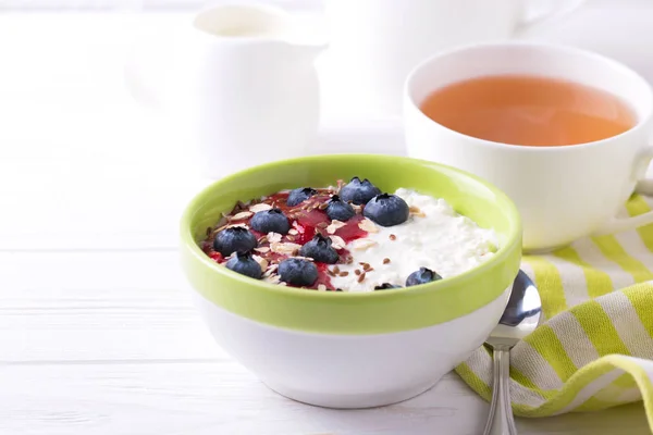 Oatmeal with blueberries, jam and yogurt with tea — Stock Photo, Image