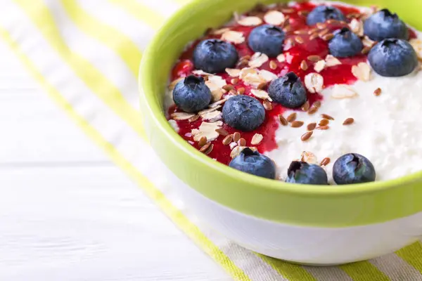 Oatmeal with blueberries, raspberry jam, flax seeds and yogurt — Stock Photo, Image