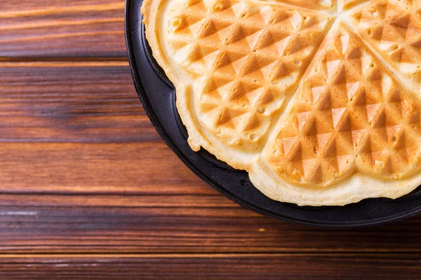 Hausgemachte herzförmige Waffeln in eiserner Waffelpfanne — Stockfoto