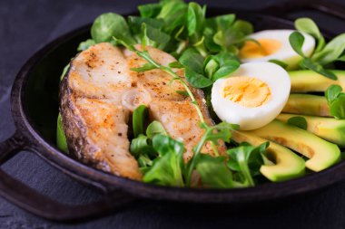 Avokado, roka ve salata ile biftek ızgara sheatfish balık