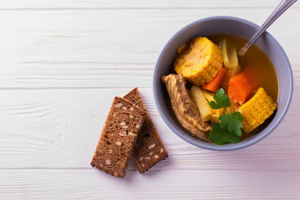 Sopa Puchero con maíz y perejil sobre mesa de madera —  Fotos de Stock