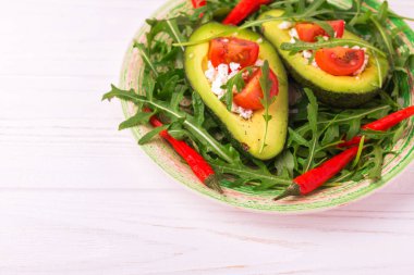 Beyaz peynir, roka ve domates ile doldurulmuş avokado