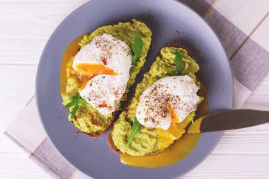 Haşlanmış yumurta ile tost, avokado, baharat ve roka püresi