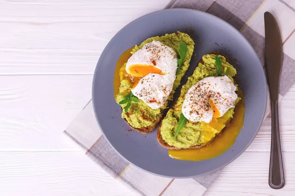 Haşlanmış yumurta ile tost, avokado, baharat ve roka püresi