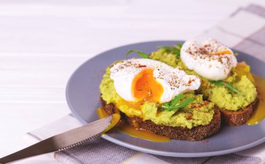 Haşlanmış yumurta ile tost, avokado, baharat ve roka püresi