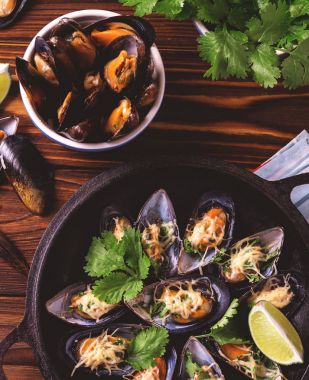 Fırında kabuklu midye peynir, kişniş ve limon ile 