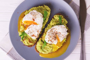 Haşlanmış yumurta ile tost, avokado, baharat ve roka püresi