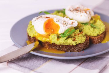 Haşlanmış yumurta ile tost, avokado, baharat ve roka püresi