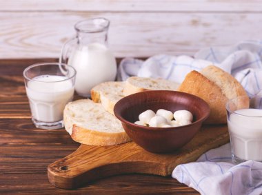 Dilimlenmiş kepekli ekmek, bardak taze süt ve mozzarella peyniri