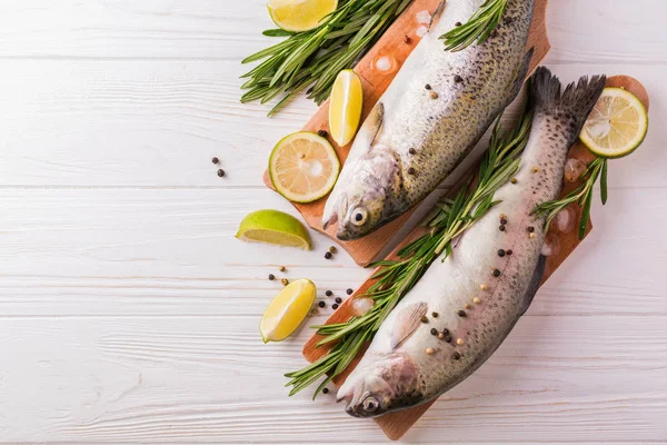 Fisk och skaldjur. Två raw regnbåge öringar marinerad med lime, rosmarin — Stockfoto