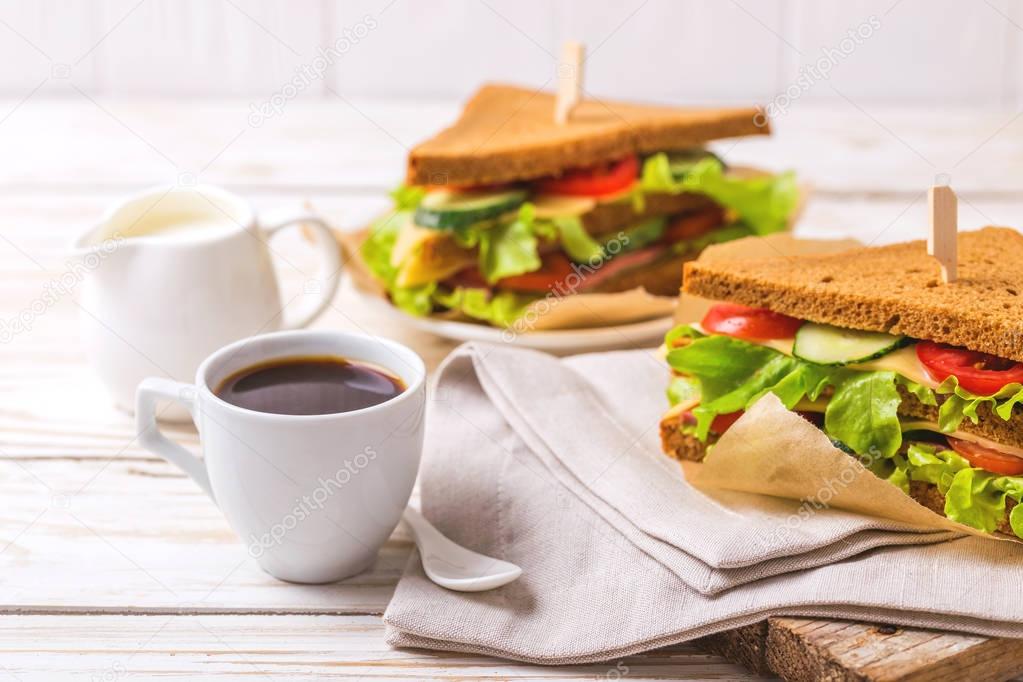 Rye bread sandwich with ham, cheese, lettuce and coffee