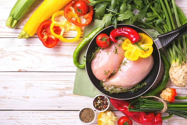 Filetes de pechuga de pollo crudo con verduras ingredientes en sartén —  Fotos de Stock