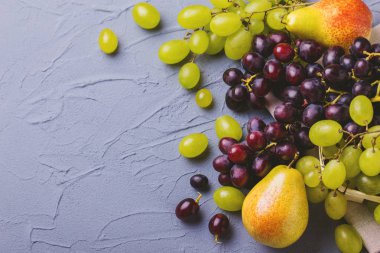 Taze üzüm ve armut gri taş zemin üzerine. Boşaltmak.