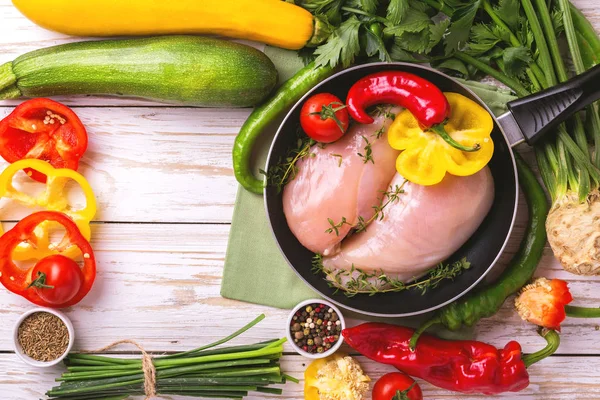 Filetes de pechuga de pollo crudo con verduras ingredientes en sartén —  Fotos de Stock