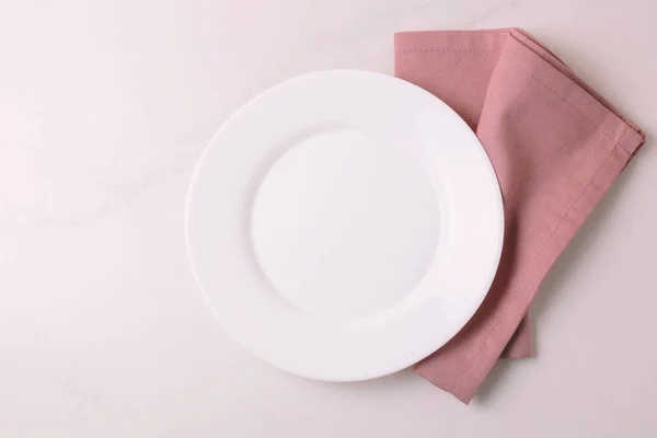 Питание. Белая пустая тарелка, салфетка. Вид сверху, копипространство . — стоковое фото