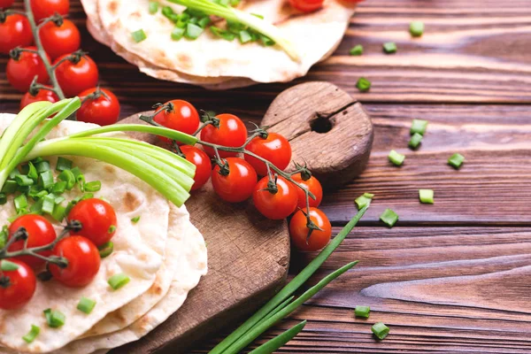 Chapati indio, cebolla verde, tomate cherry. Vista superior, plano . — Foto de Stock