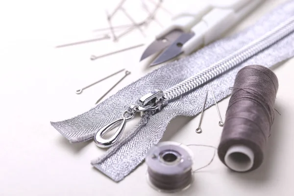 Sewing pins, scissors, zipper and plastic bobbin with colour thr — Stock Photo, Image