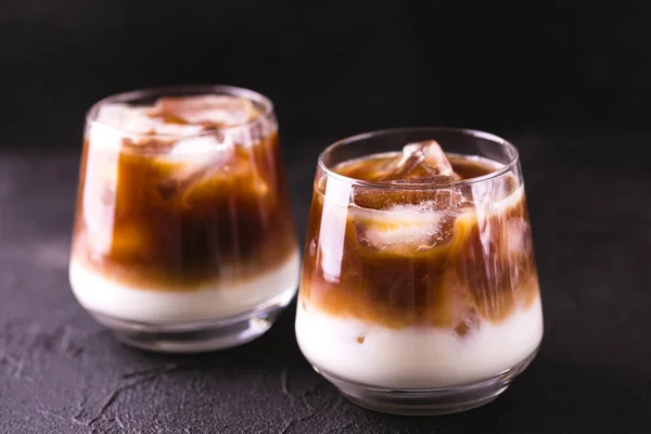 Iskaffe i glas med mjölk. Svart bakgrund — Stockfoto