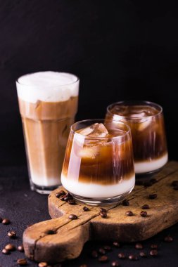 Süt ile bardaklarda buzlu kahve. Siyah arka plan