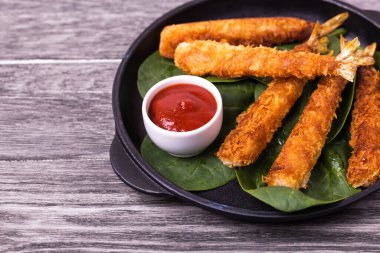 Tempura, ahşap arka planda domates soslu kızarmış karides balığı. Asya sokak yemekleri.