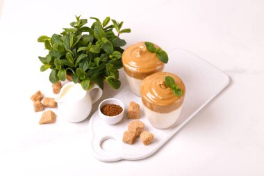 Sütlü ve baston şekerli dalgona kahvesi. Güney Kore 'de moda soğuk yaz içeceği