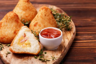 Sicilyalı arancini di riso. Kızarmış pilav topları. İtalyan yemeği. Tavuk hindiba, sebzeli Brezilya çerezi ve domates sosu.