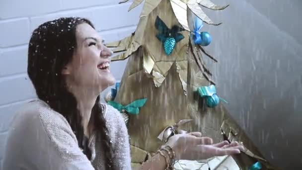 お祝いと人々 の概念 - 笑いとクリスマス ツリーの背景、メリー クリスマス、新年あけましておめでとうございますの上の雪を引く若い女性 — ストック動画