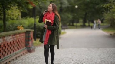 muhteşem güzel mutlu kadın telefonla konuşuyor ve gülümseyen güneşli sonbahar doğa bir arka plan üzerinde öğrenci kız sonbahar parkta yürüyüş